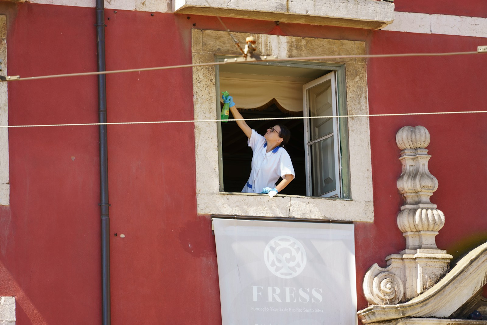 A man waving from a window of a building