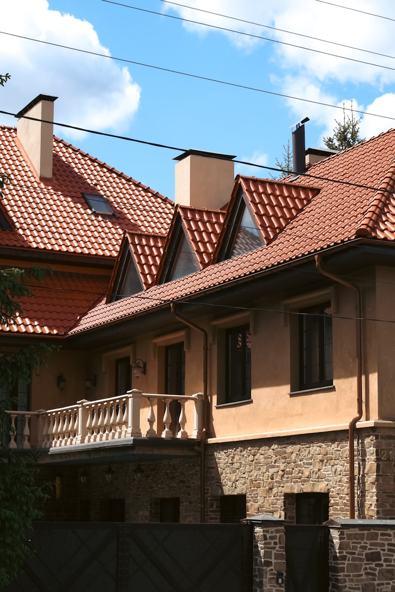 a house with a red tiled roof and a black gate